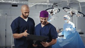 A diverse surgical team collaborating in a modern operating room setting, highlighting teamwork, expertise, and healthcare professionalism. Surgeons Examining X-ray in OR - Powered by Shutterstock - Get 15% off with code: PIKWIZARD15