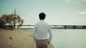 Man Standing Alone On Riverbank Beach. Serene Relaxation, Peaceful Solitude. Urban Escape Thoughtful Moment. Reflective Time Contemplative Mood On Sandy Shore. Weekend Mood Personal Freedom Relaxation - Powered by Shutterstock - Get 15% off with code: PIKWIZARD15
