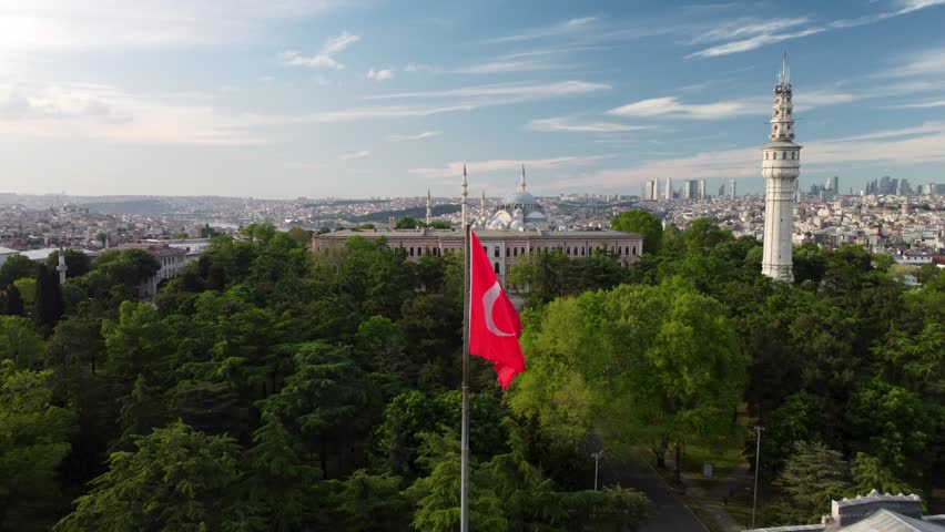 Cinematic 4K drone footage of the Turkish flag waving in Istanbul. Pull back and ascend shot reveals the cityscape and skyline. Ideal for travel, culture, and national pride projects.