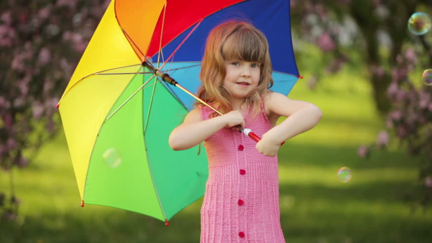 Sweet girl with umbrella smiling at camera
