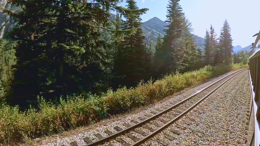 White Pass route train ride between Skagway Alaska and Whitehorse Yukon Canada. Beautiful sunny day with white clouds and blue sky