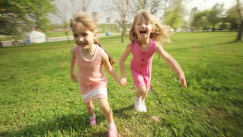 Sisters running around in garden and laughing
