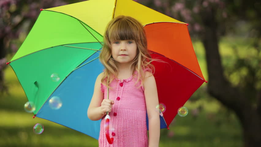 Little kid with umbrella laughing
