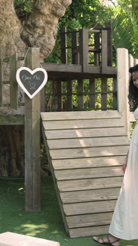 Vertical video: Man kneeling in backyard seeing chalk sign, presenting ring and embracing her. Romance, celebration, outdoor, rustic, joyful, commitment, vertical video