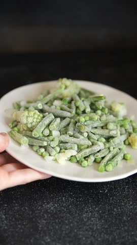 Frozen green vegetables green peas, broccoli, string beans, kohlrabi kale tasty snack fresh food background on the table rustic food top view copy space keto and paleo diet vegan and vegetarian food