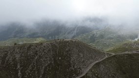 Couple walking on mountain top near the clouds in the Dolomites, Italy - Powered by Shutterstock - Get 15% off with code: PIKWIZARD15