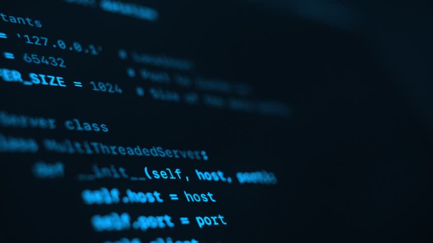 Close up of blue programming code running on dark computer screen. Programming and coding concept.