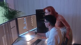 Two developer or programmer colleagues collaborating on programming and data analysis using monitors. They discuss code review system logs and share ideas in a modern office. Teamwork and technology. - Powered by Shutterstock - Get 15% off with code: PIKWIZARD15