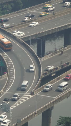 Aerial view of traffic junction cross road with car transport in Bangkok. Vertical video
