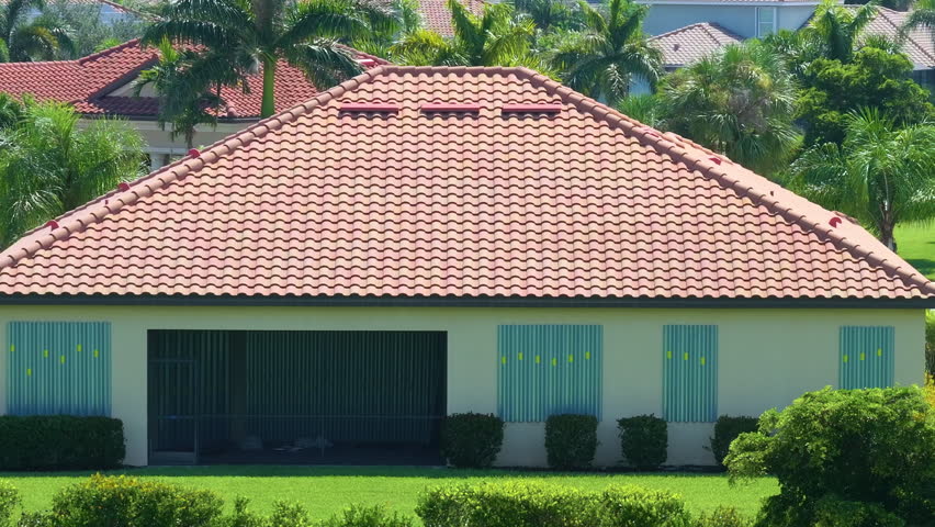 Boarded up windows with steel storm shutters for hurricane protection of residential house. Protective measures before natural disaster in Florida