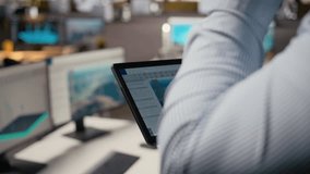 Close up of engineer in office using tablet to work on wind turbine CAD design, doing sustainable energy research. Worker doing digital modeling of wind energy generator gear on device, camera A - Powered by Shutterstock - Get 15% off with code: PIKWIZARD15