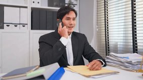 Asian businessman lawyer talking on phone while working in courtroom. Attractive male attorney communicate with smartphone call at his desk in legal office. Law and Legal business services concept. - Powered by Shutterstock - Get 15% off with code: PIKWIZARD15