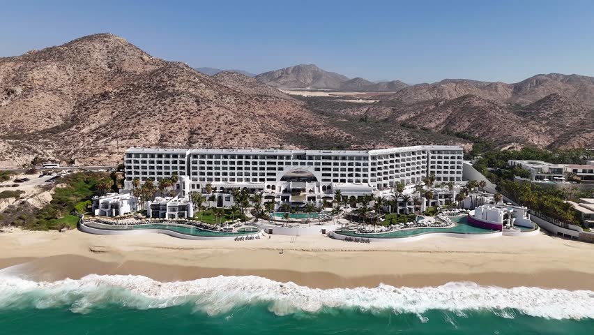 Cabo San Lucas, Mexico. Drone Shot of Luxury Beachfront Resort, Highway Traffic and Pacific Ocean Waves