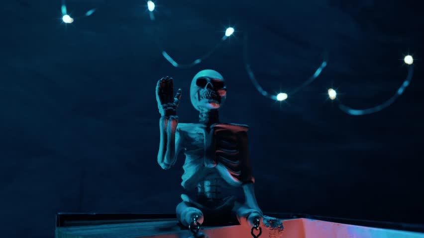 Halloween Stories. Skeleton and shining garlands in mysterious blue light on chalk board background.Halloween books.