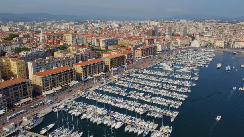 aerial shot captures the vibrant Vieux-Port of Marseille, France, bustling with numerous yachts and boats docked in its marina.