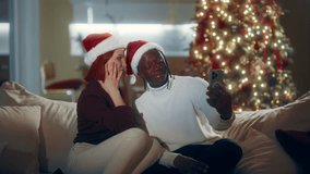 Multiethnic man and woman using phone for take selfie and video call in Xmas. Joyful diverse people celebrating traditional winter holyday and using modern mobile gadget, Caucasian and African ethnic - Powered by Shutterstock - Get 15% off with code: PIKWIZARD15