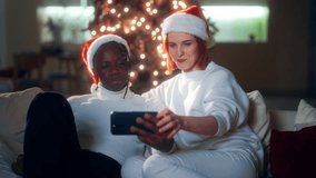 Celebrate Christmas and new year, portrait of african man and caucasian lady. Loving couple chatting online with friends and family by video conference in modern smartphone, happy faces and smiles - Powered by Shutterstock - Get 15% off with code: PIKWIZARD15