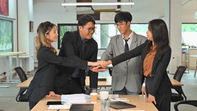 Business colleagues standing around a table showing unity and agreement through a group hand stack - Powered by Shutterstock - Get 15% off with code: PIKWIZARD15