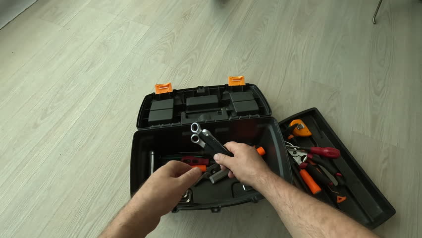 POV male mechanic's hands packing tool into toolbox in the room