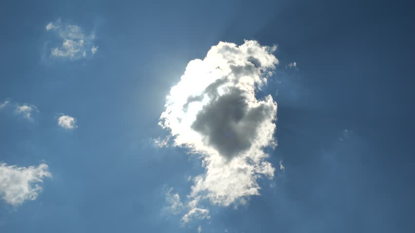 The bright sun appears from behind a small cumulus cloud
