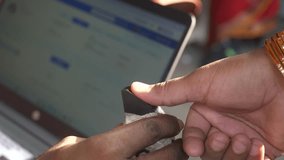 On site biometric fingerprint scanner to register National Health Authority public health insurance scheme at rural vaccination center, National Rural Health Mission initiative, Begusarai, Bihar - Powered by Shutterstock - Get 15% off with code: PIKWIZARD15
