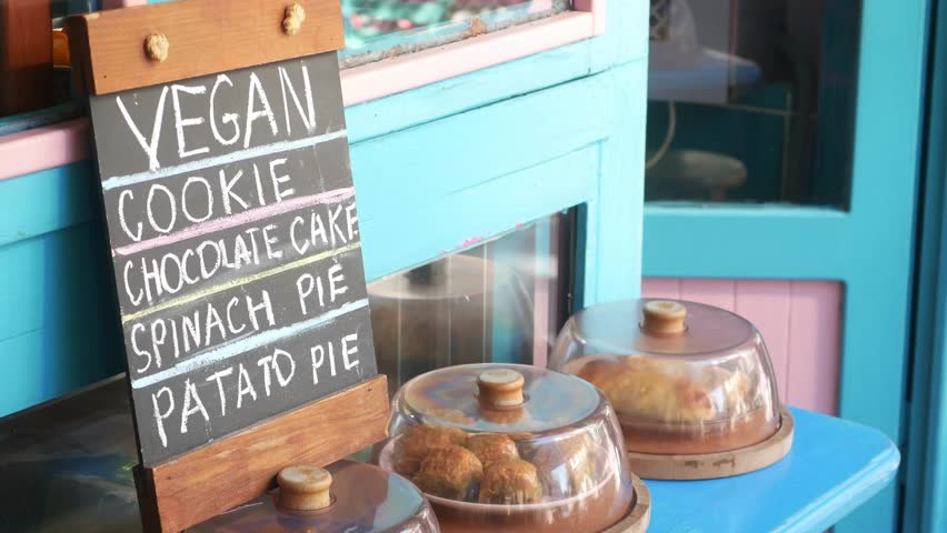 Vegan treats display at bakery with colorful storefront