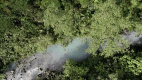 A couple is seen swimming in the vibrant, turquoise blue waters of Las Gemelas waterfalls,close of the cascading falls, which are nestled within a dense and lush jungle. - Powered by Shutterstock - Get 15% off with code: PIKWIZARD15