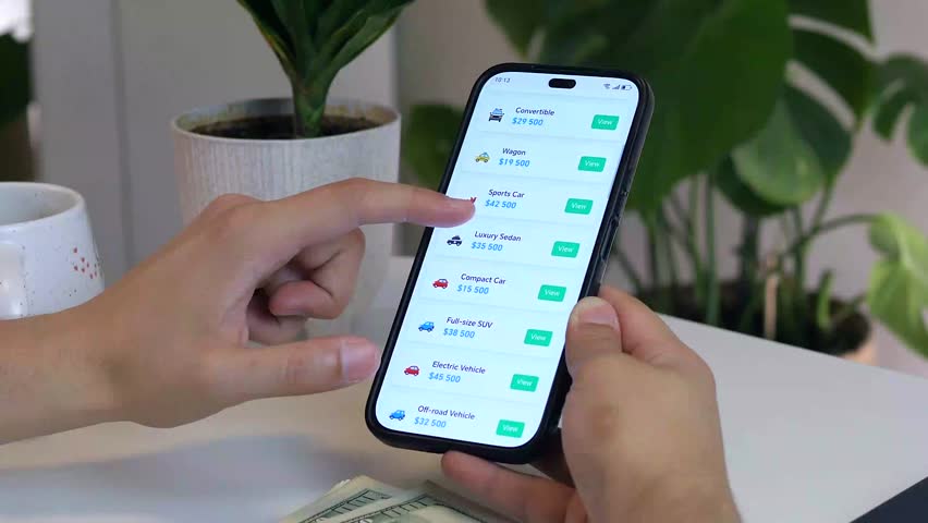 Hands explore online listings for mid-priced cars on a phone, with cash nearby, reflecting a serious purchase intent. Perfect for automotive marketing, financial planning, or buyer journeys.