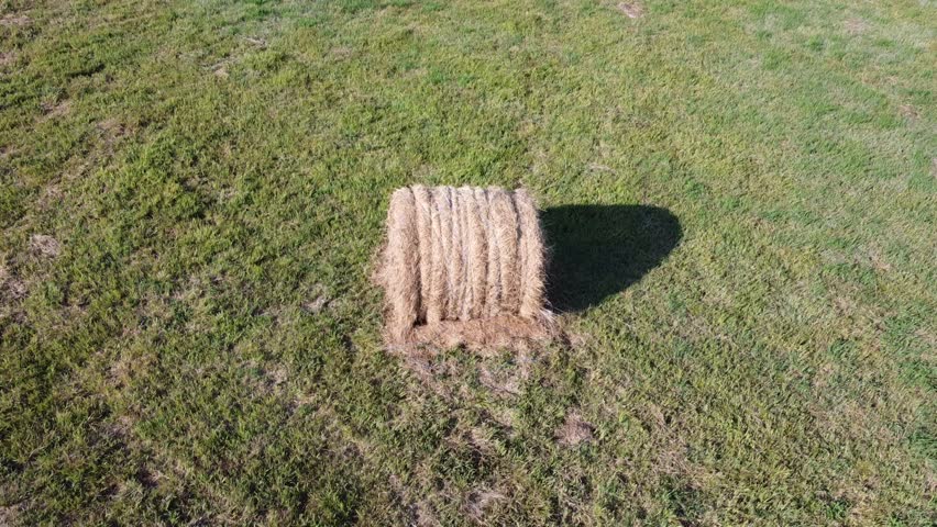 Aerial Video going up Around Round Hay Bale in Countryside Field