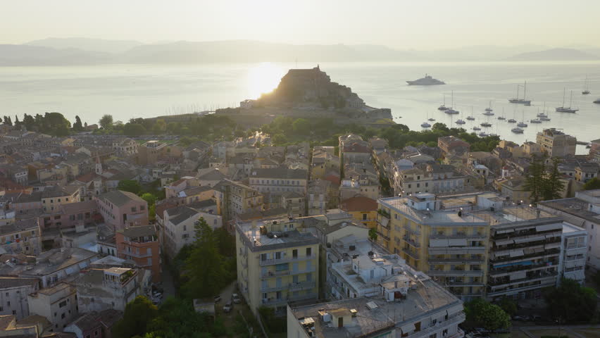 The Old Fortress in old town of Corfu during sunrise with flock of swallows flying around, Drone shot