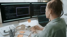 Unrecognizable female programmer focused on typing codes while working in IT office. She sitting at desk with office supplies and digital devices - Powered by Shutterstock - Get 15% off with code: PIKWIZARD15