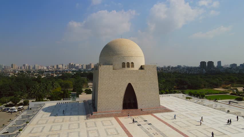 Aerial view of the Mazar-e-Quaid monument, a mausoleum with a large dome and geometric patterns, surrounded by lush green trees, Karachi, Sindh, Pakistan.