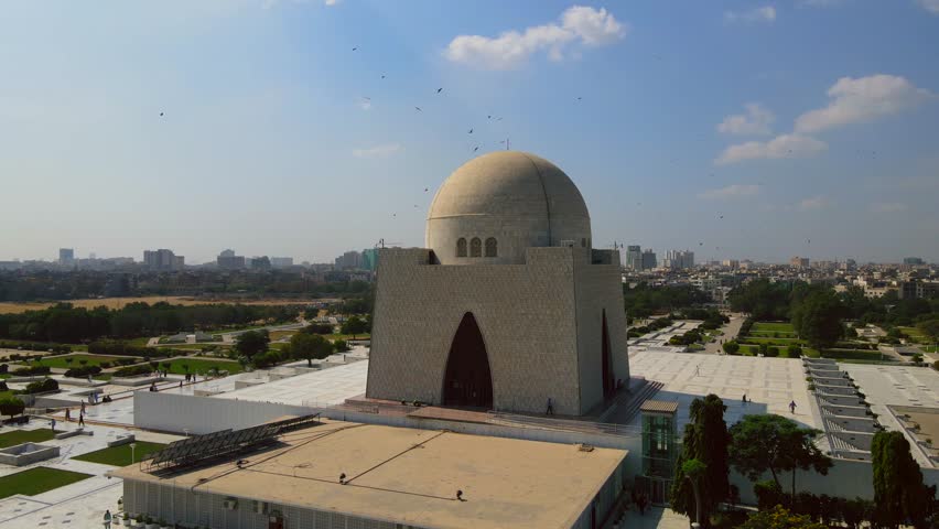 Aerial view of the Mazar-e-Quaid, a mausoleum with a large dome, set against a backdrop of the city skyline, Karachi, Sindh, Pakistan.