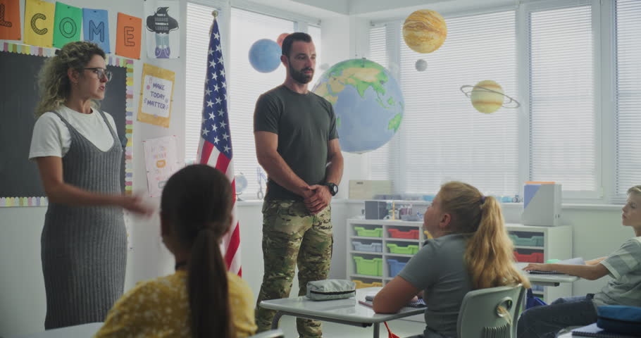 American Military Man Giving Lecture to Curious Primary School Students About Discipline, Military Science and Army. Female Teacher Standing Nearby, Children Listening During Career Education Lesson.