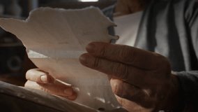 Elderly woman wrinkled hands hold piece of torn aged paper evoking memories at home closeup. Idea of nostalgia and past experiences and passage of time - Powered by Shutterstock - Get 15% off with code: PIKWIZARD15