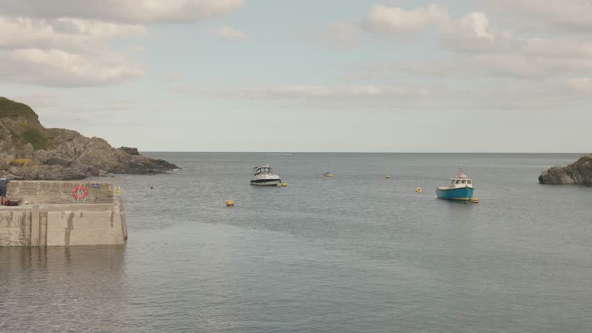 panning shot of boats anchored in the beautiful village of Polperro in Cornwall