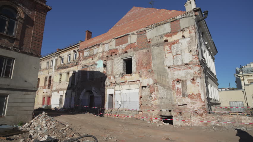 Half-ruined structure surrounded by warning tape shows fragile state. Abandoned building radiates unsafe atmosphere of urban drama