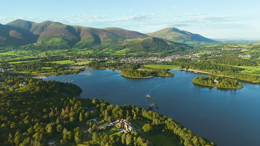 Scenic landscape of the Lake District fells, lake, Keswick, and town during golden hour