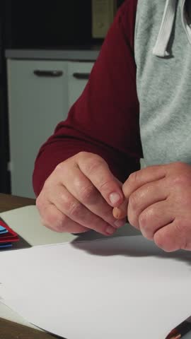 Middle aged man signs important documents in a cozy home office setting during the afternoon