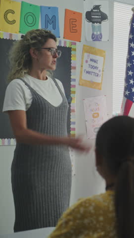 American Military Man Giving Lecture to Curious Primary School Students About Military Science, Army. Female Teacher Standing Nearby, Children Listening During Career Education Lesson. Vertical Shot.