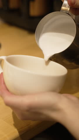 This footage captures the art of pouring steamed milk into a white coffee cup, showcasing the creamy texture and inviting appearance of a freshly made beverage, fa01