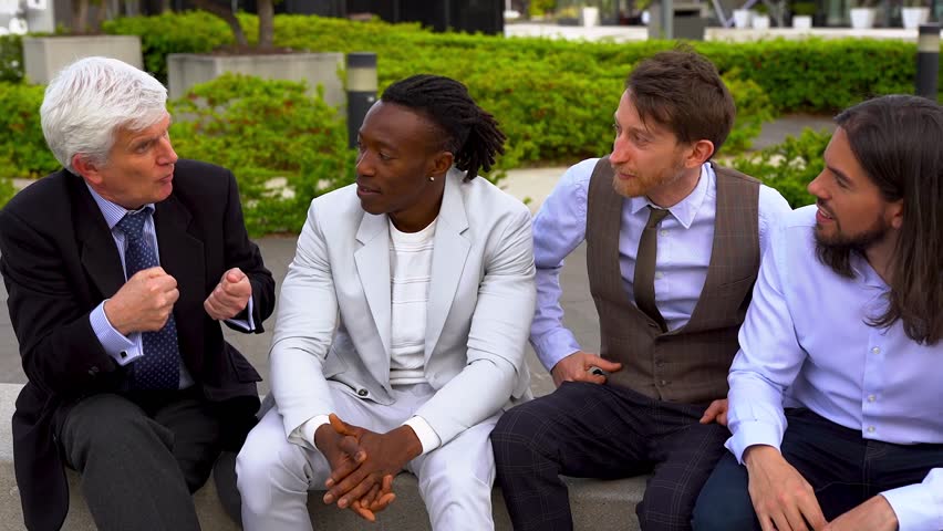 Multi generational business men talking together outside of office during lunch break - Multiracial colleagues and entrepreneur concept	