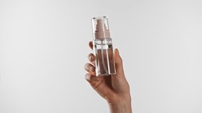 A hand holds a clear bottle, ideal for skincare product presentation or cosmetic branding opportunities. - Powered by Shutterstock - Get 15% off with code: PIKWIZARD15