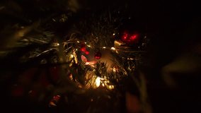 Red Christmas Ornament Hanging on Tree Among Pine Needles Ribbons and Lights Captured in Zoom View Through Dense Holiday Branches. - Powered by Shutterstock - Get 15% off with code: PIKWIZARD15