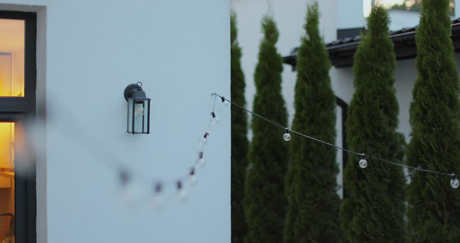 String lights hanging on line on outside house in backyard. Garden decoration. Party camping.