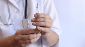 Close-up of a doctor's hands holding a syringe. Syringe with medicine. A doctor in a white coat and with a stethoscope holds a syringe. Medical injections. Nurse or doctor. Medical care in a hospital - Powered by Shutterstock - Get 15% off with code: PIKWIZARD15