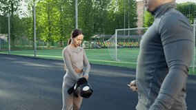 Boxer jumping using skipping rope. Woman is putting on boxer gloves. Man and woman warming up for box training at sports ground. Boxer routine. 4K, UHD - Powered by Shutterstock - Get 15% off with code: PIKWIZARD15