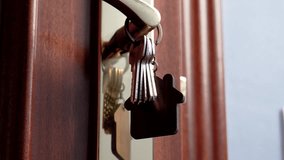 Hand picking up bunch of apartment keys with wooden house shaped keychain hanging on golden door handle - Powered by Shutterstock - Get 15% off with code: PIKWIZARD15