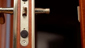 Hand of homeowner hanging home keys with keychain in house shape on handle of open apartment door - Powered by Shutterstock - Get 15% off with code: PIKWIZARD15