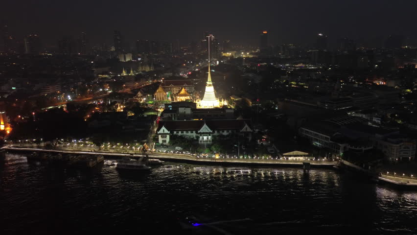 Aerial around view on night lights of Wat Prayurawongsawas Warawihan pagoda, Bangkok, Thailand, 4k